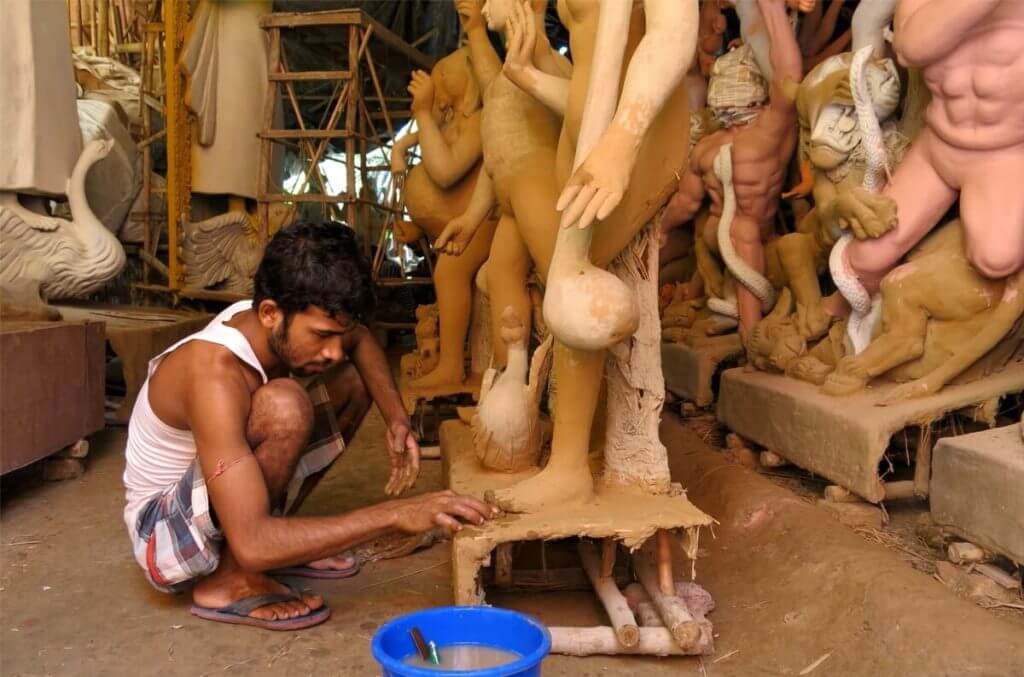 An artisan adds finishing touches to the raw clay idol of Goddess Saraswati. Image ©2017 Jasmine Trails