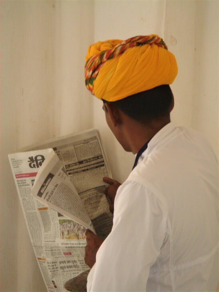 Jasmine Trails newsletter sign up page. In the image is a man in a traditional turban reading a newspaper in Jodhpur